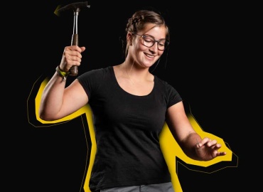 Eine junge Frau mit einem Hammer in der Hand.